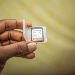 Kartu memori SD card yang dipegang tangan untuk dipasang di perangkat